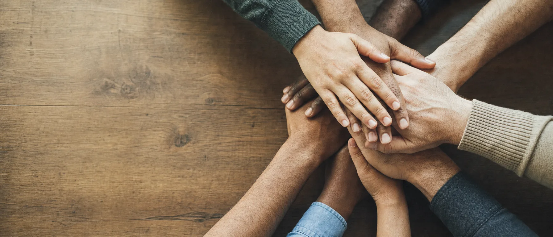 Mãos sobrepostas em gesto de pacto coletivo